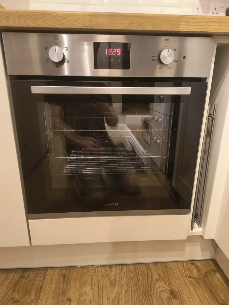 Professional oven cleaner removing oven door for deep cleaning